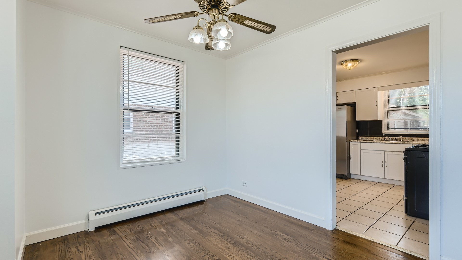 10718 South Pulaski Road Oak Lawn, IL 60453 - Photo 8 of 28 an empty room with wooden floor a chandelier fan and windows