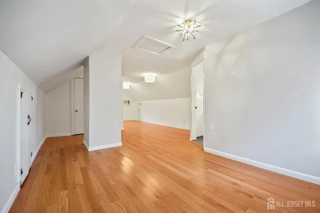 a view of empty room with wooden floor