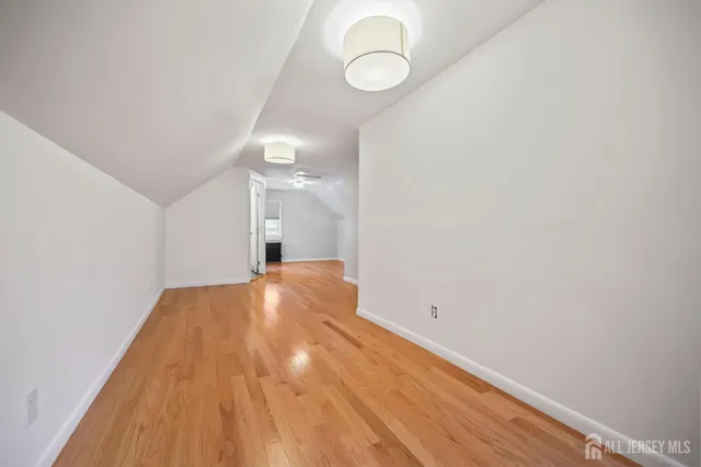 a view of a room with wooden floor and white walls