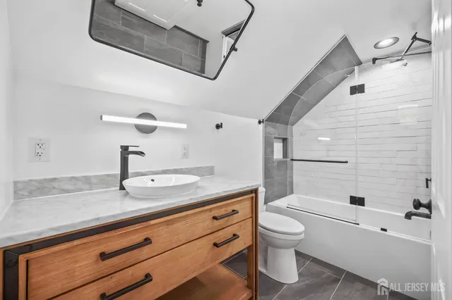 a spacious bathroom with a granite countertop sink a toilet and a shower