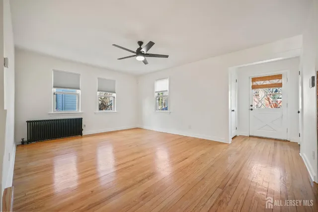 a view of a livingroom with wooden floor and a ceiling fan