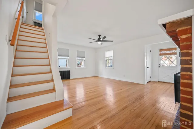 a view of a livingroom with wooden floor and a ceiling fan