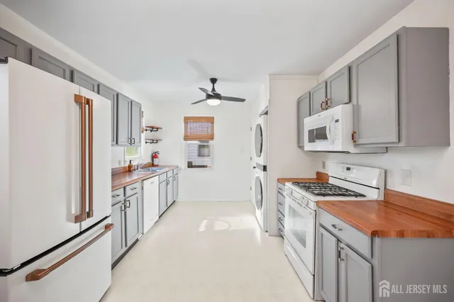 a kitchen with stainless steel appliances granite countertop a refrigerator a stove and a sink