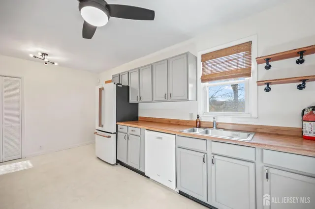 a kitchen with white cabinets and sink