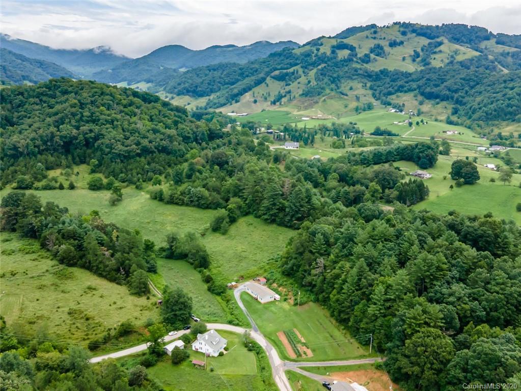354 Lost Cove Road Clyde, NC 28721 - Photo 13 of 13 an aerial view of green landscape with trees houses and mountain view