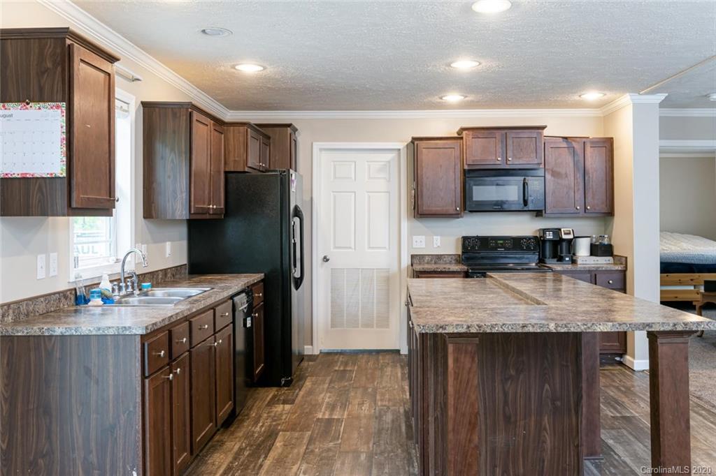 354 Lost Cove Road Clyde, NC 28721 - Photo 4 of 13 a kitchen with stainless steel appliances granite countertop a refrigerator a stove a sink and a microwave