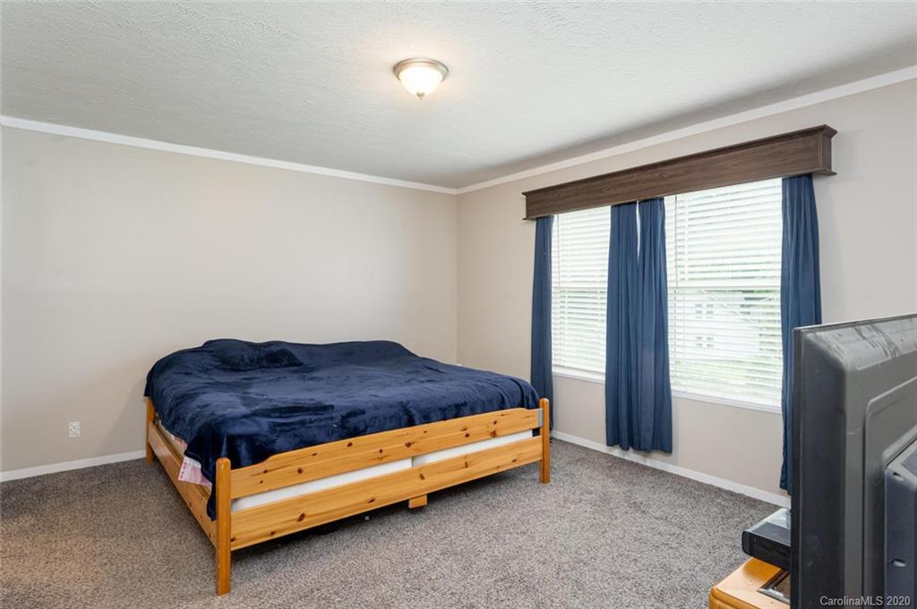 354 Lost Cove Road Clyde, NC 28721 - Photo 6 of 13 a bed sitting in a bedroom next to a window