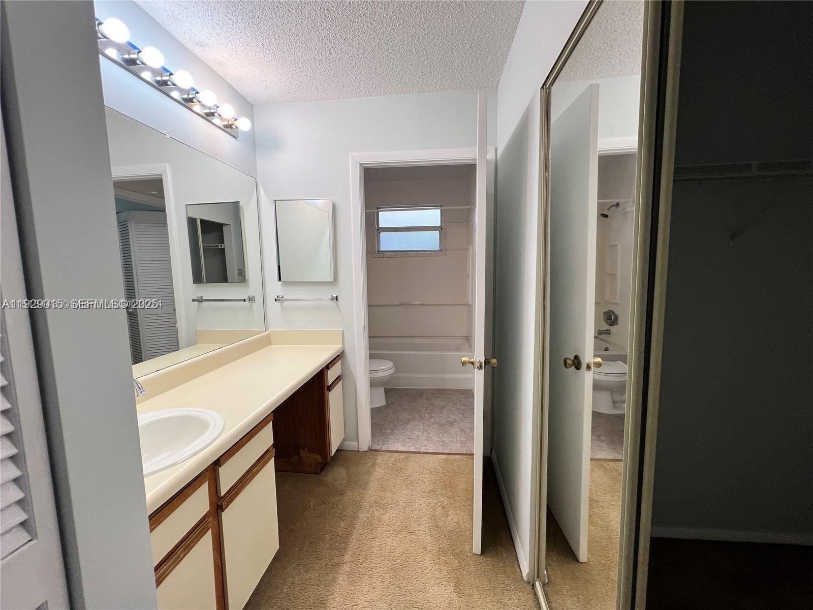 665 Southwest 113th Way, Unit 665 Pembroke Pines, FL 33025 - Photo 19 of 24 a bathroom with a double vanity sink a mirror and a shower
