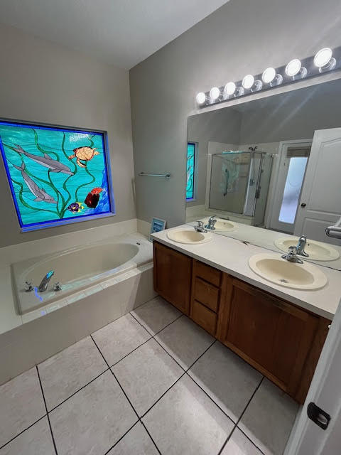 895 Northwest Sassafras Terrace Stuart, FL 34994 - Photo 11 of 23 a bathroom with a sink a large mirror and a bathtub