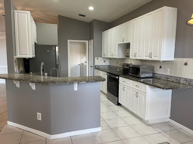 895 Northwest Sassafras Terrace Stuart, FL 34994 - Photo 6 of 23 a kitchen with stainless steel appliances granite countertop a sink a stove and a refrigerator