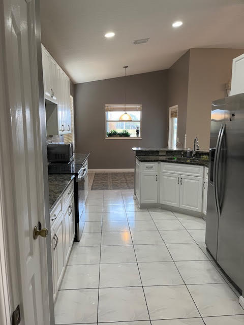 895 Northwest Sassafras Terrace Stuart, FL 34994 - Photo 7 of 23 a kitchen with stainless steel appliances granite countertop a stove a sink and a refrigerator