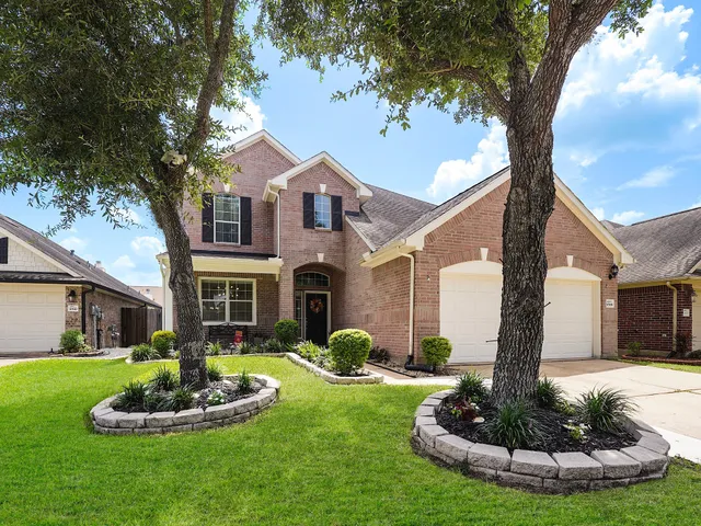 a front view of a house with a yard garage and fountain