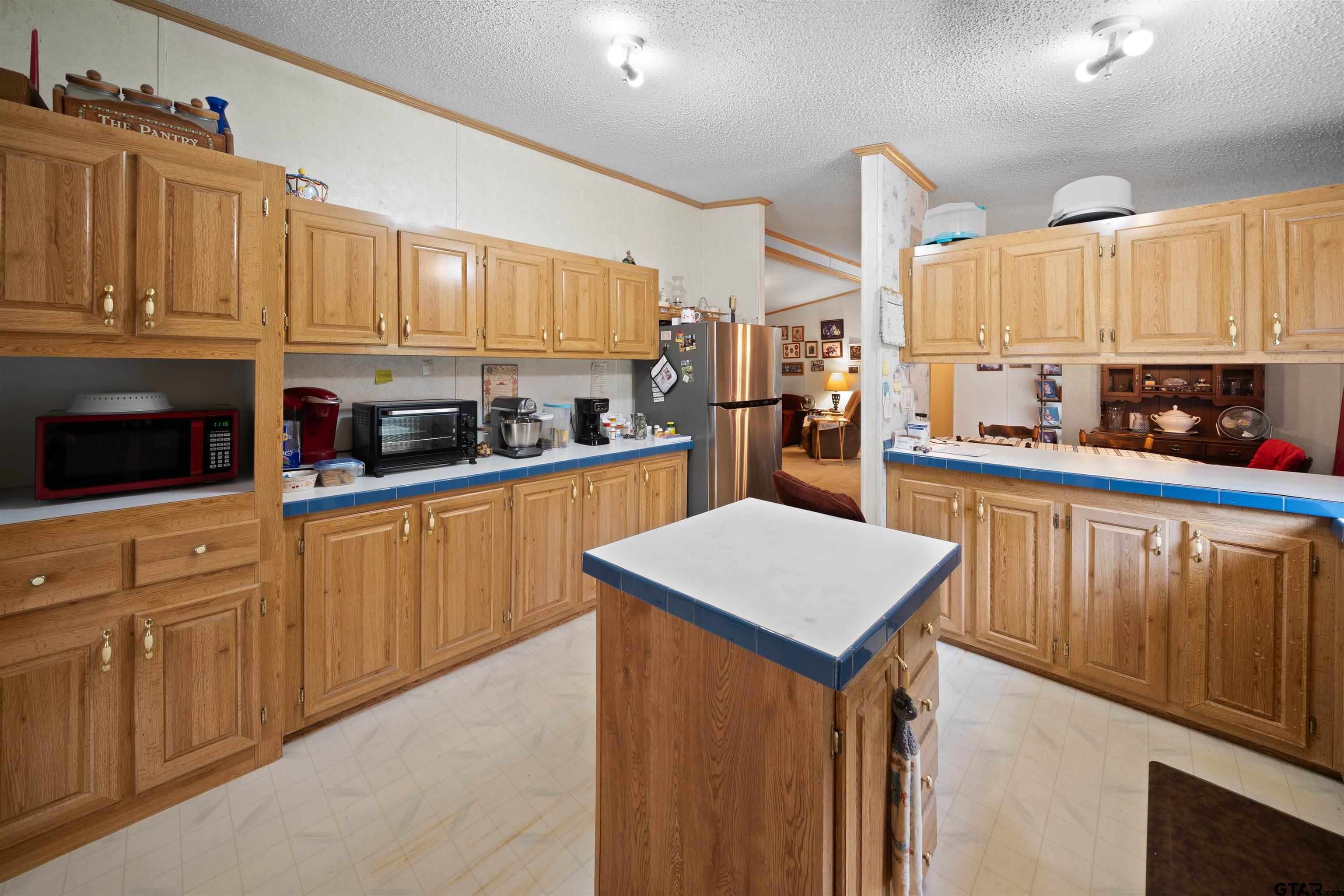 2425 Thompson Lane Tyler, TX 75704 - Photo 12 of 27 a kitchen with stainless steel appliances granite countertop a sink stove microwave and cabinets