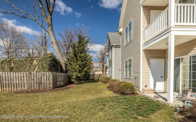 a view of a house with a floor to ceiling window and wooden fence
