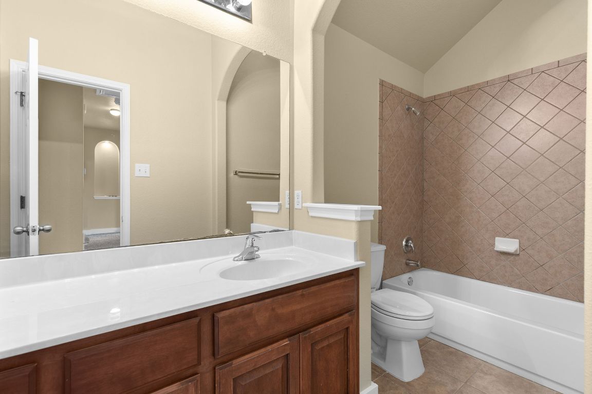 10128 Channel Island Drive Austin, TX 78747 - Photo 22 of 39 a bathroom with a sink a toilet and shower