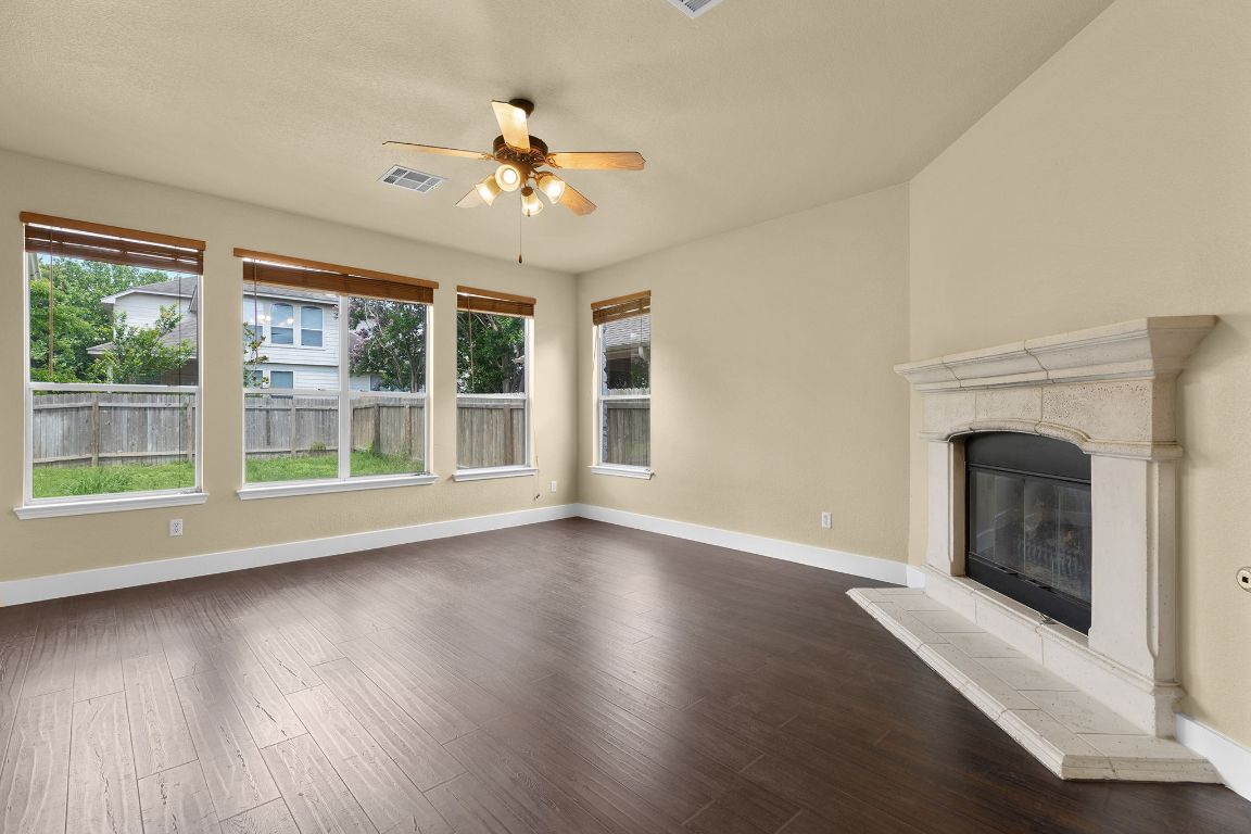 10128 Channel Island Drive Austin, TX 78747 - Photo 8 of 39 a view of an empty room with wooden floor and a fireplace