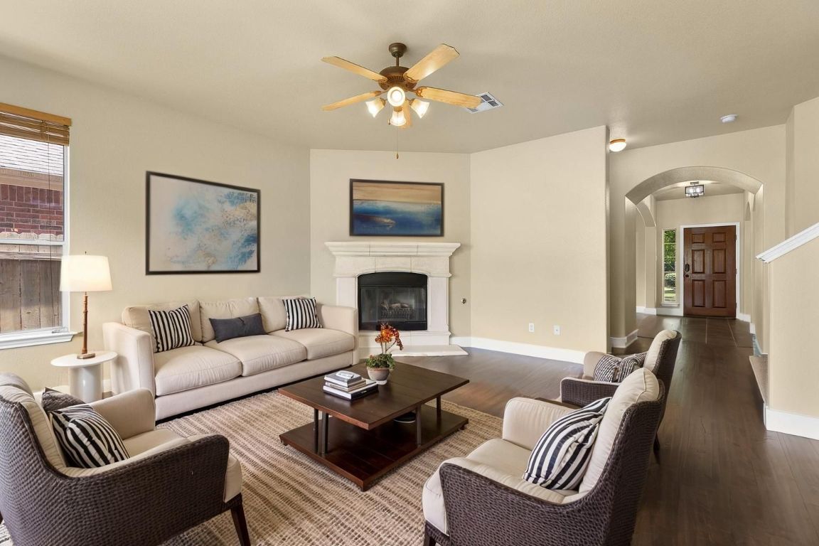 10128 Channel Island Drive Austin, TX 78747 - Photo 9 of 39 a living room with furniture a fireplace and a chandelier