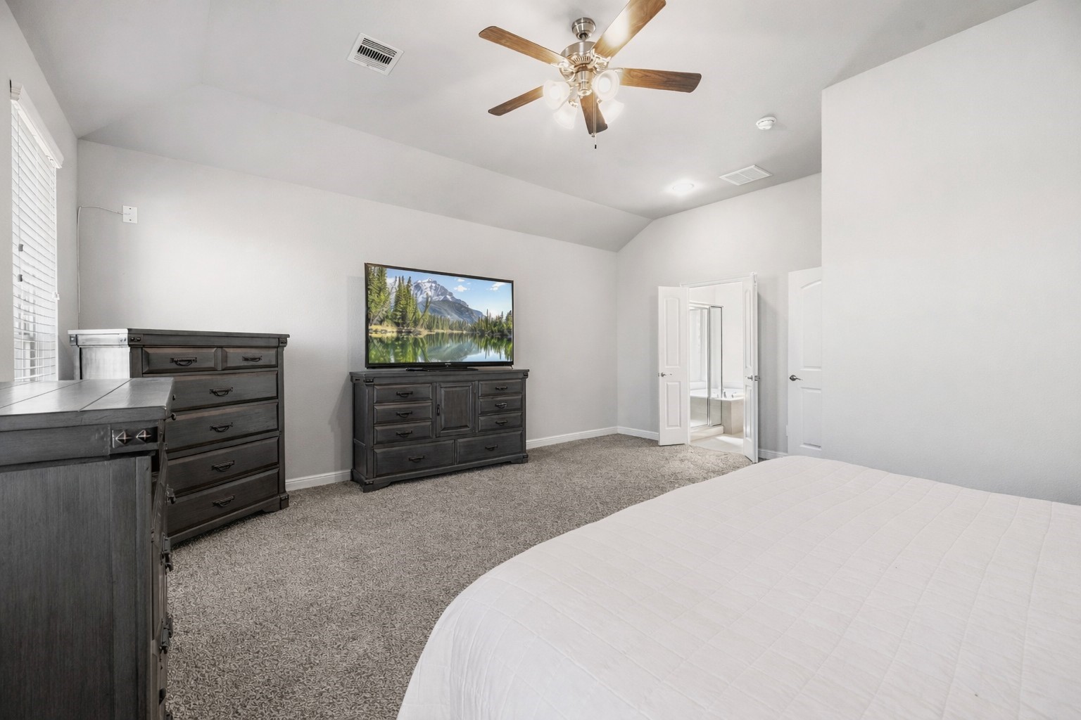 3319 Learning Tree Lane Rosenberg, TX 77471 - Photo 11 of 44 a spacious bedroom with a bed and a chandelier