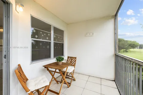 a patio with table and chairs and potted plants