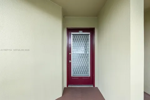 a view of a hallway with wooden floor and a bathroom