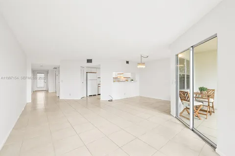 a view of empty room with cabinet and view of bathroom