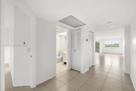 a view of a hallway with bathroom and a bathroom