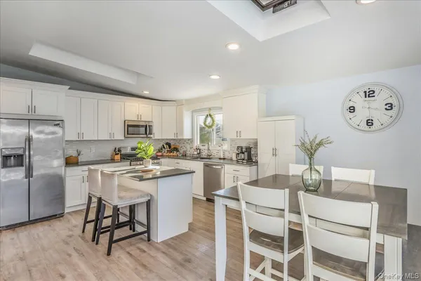 a kitchen with white cabinets and stainless steel appliances