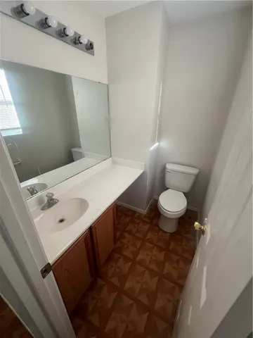 a bathroom with a sink a toilet a mirror and vanity