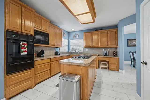 a kitchen with stainless steel appliances granite countertop a stove sink and cabinets
