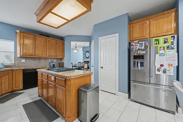 a kitchen with stainless steel appliances granite countertop a refrigerator and a stove