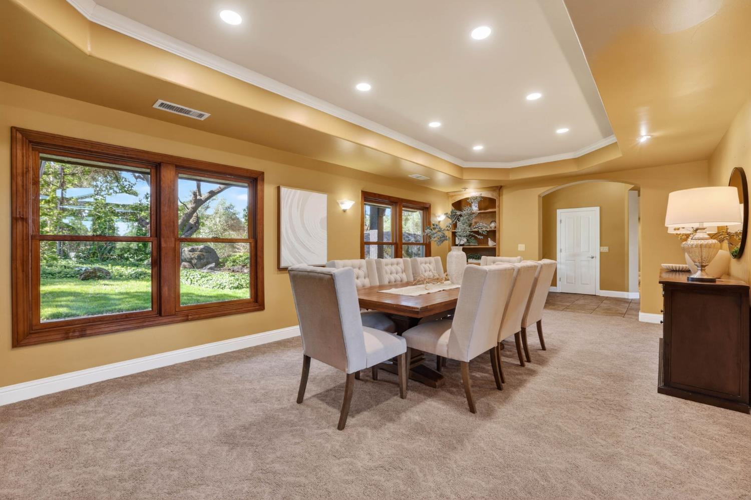 7021 Horseshoe Bar Road Loomis, CA 95650 - Photo 15 of 77 Expansive formal dining room filled with natural light, showcasing beautiful window-lined views and a seamless open flow ideal for gatherings both large and small.