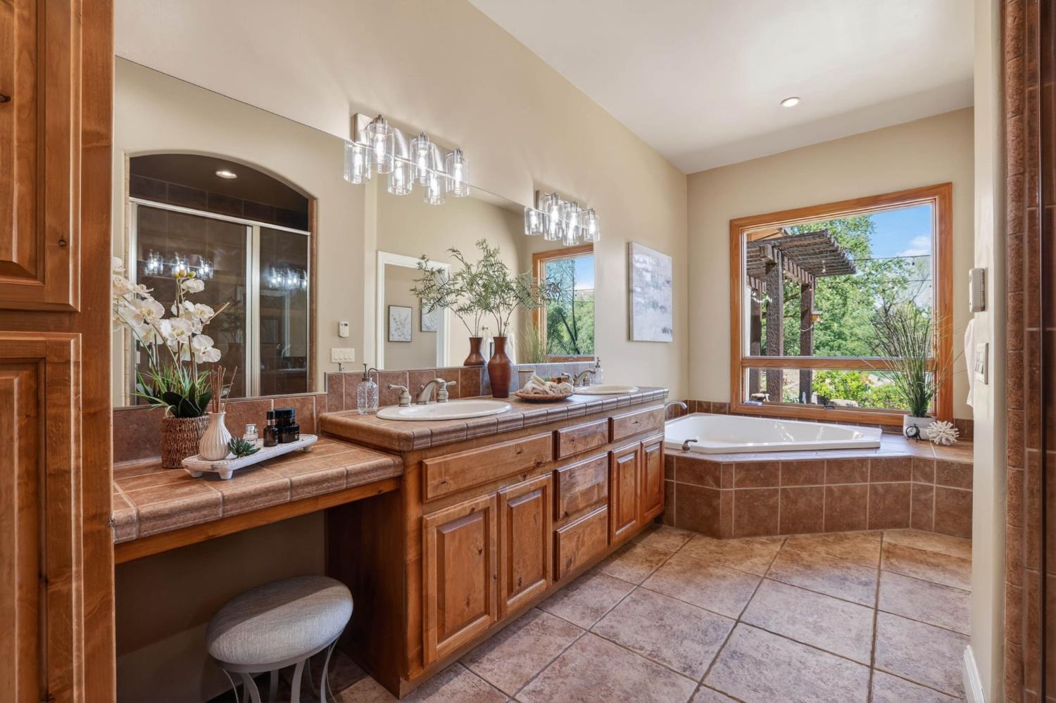 7021 Horseshoe Bar Road Loomis, CA 95650 - Photo 21 of 77 Spa-inspired primary bathroom featuring dual sinks, a soaking tub and a stunning view overlooking the creek as it flows into the pond.