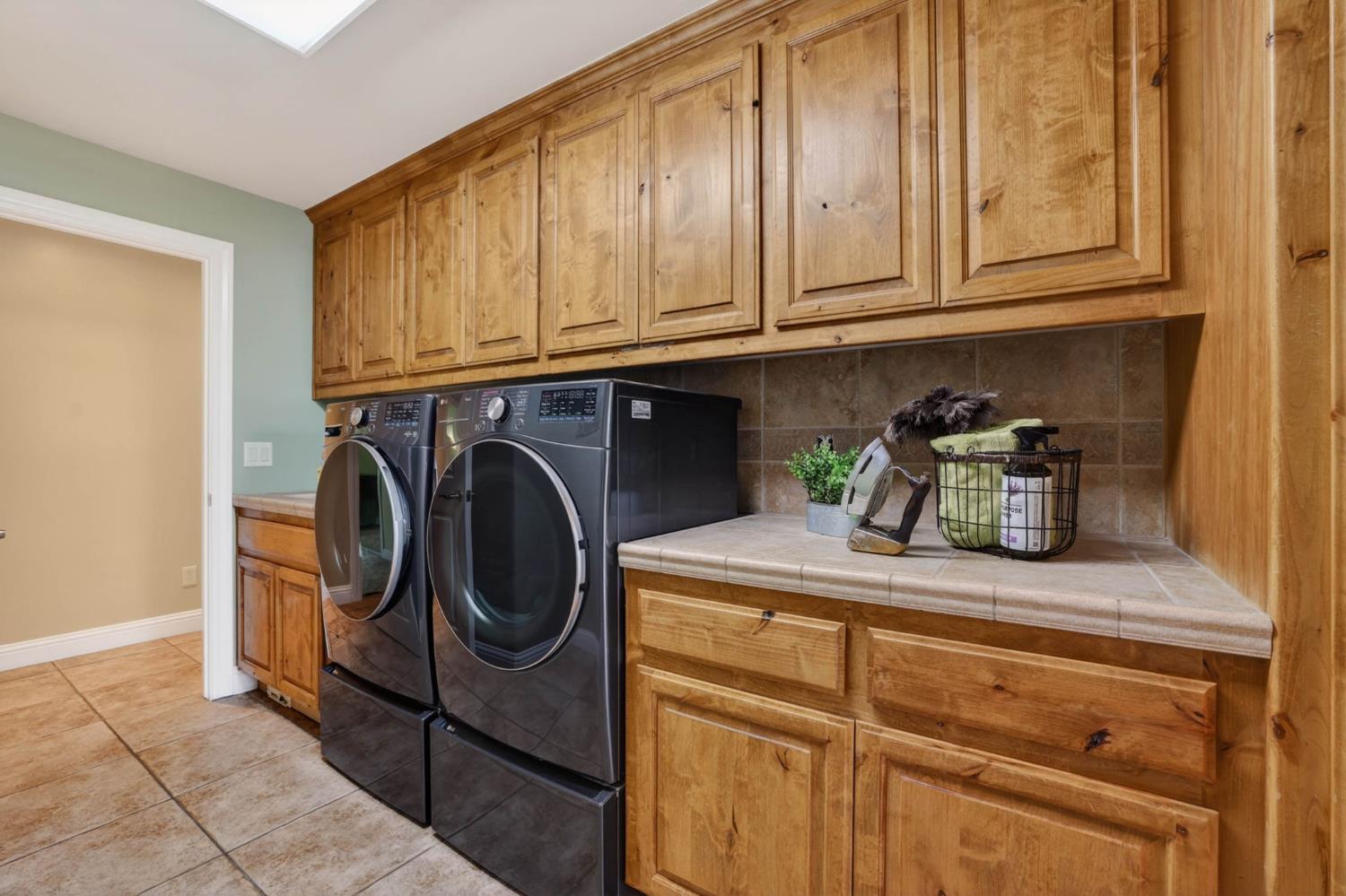 7021 Horseshoe Bar Road Loomis, CA 95650 - Photo 25 of 77 Generously sized laundry room with extensive cabinetry, ample counter space for folding, built-in ironing board, deep utility sink, and a room for full size appliances.