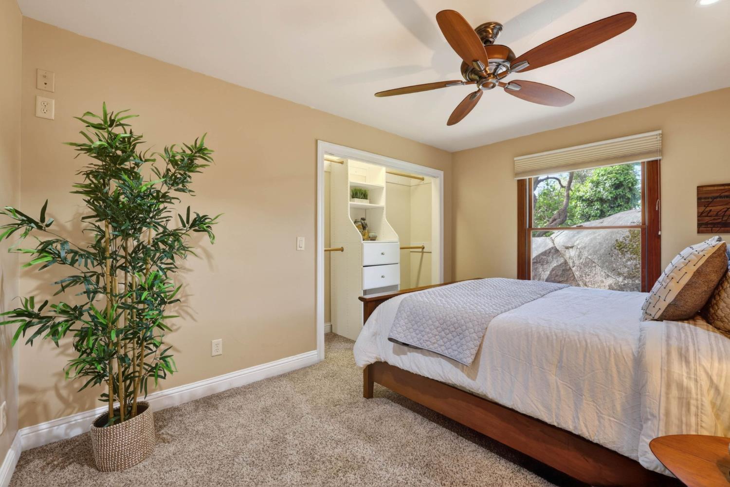 7021 Horseshoe Bar Road Loomis, CA 95650 - Photo 26 of 77 Guest bedroom with a distinctive natural boulder outcropping, creating a one-of-a-kind feature that blends indoor living with the surrounding landscape.