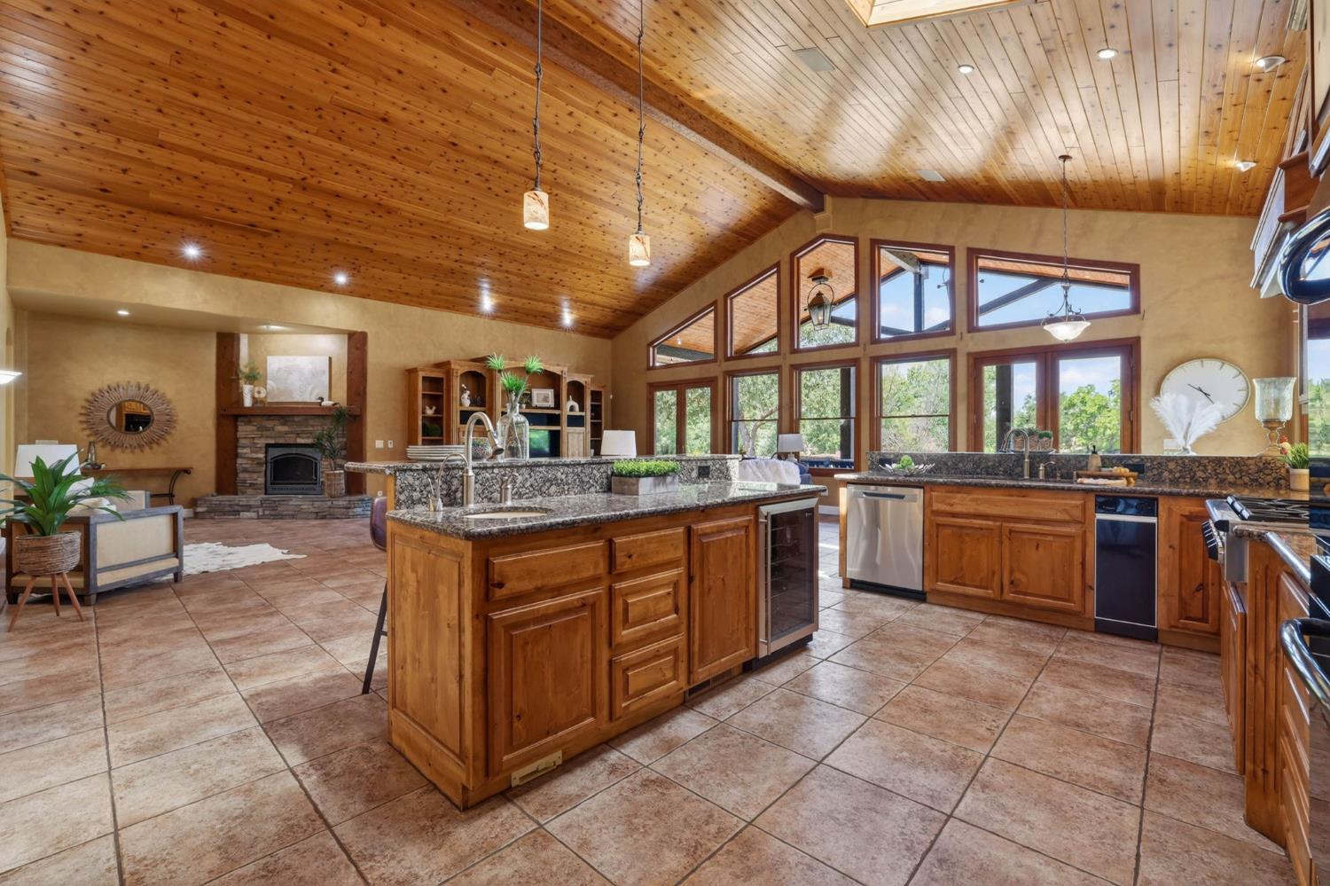 7021 Horseshoe Bar Road Loomis, CA 95650 - Photo 10 of 77 A chef's Kitchen featuring a wine refrigerator, dishwasher, trash compactor, gas stove and radiant floors. All overlooking the creek and pond natural settings.