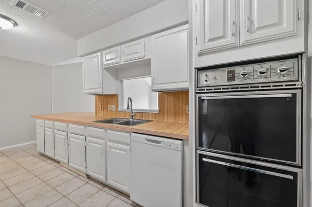 a kitchen with white cabinets and appliances