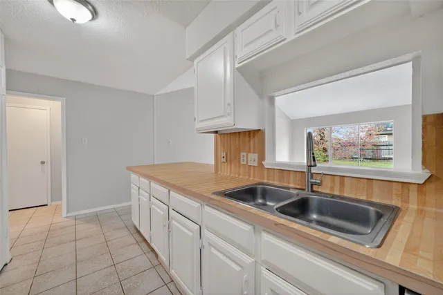 a kitchen with stainless steel appliances granite countertop a sink and a white cabinets