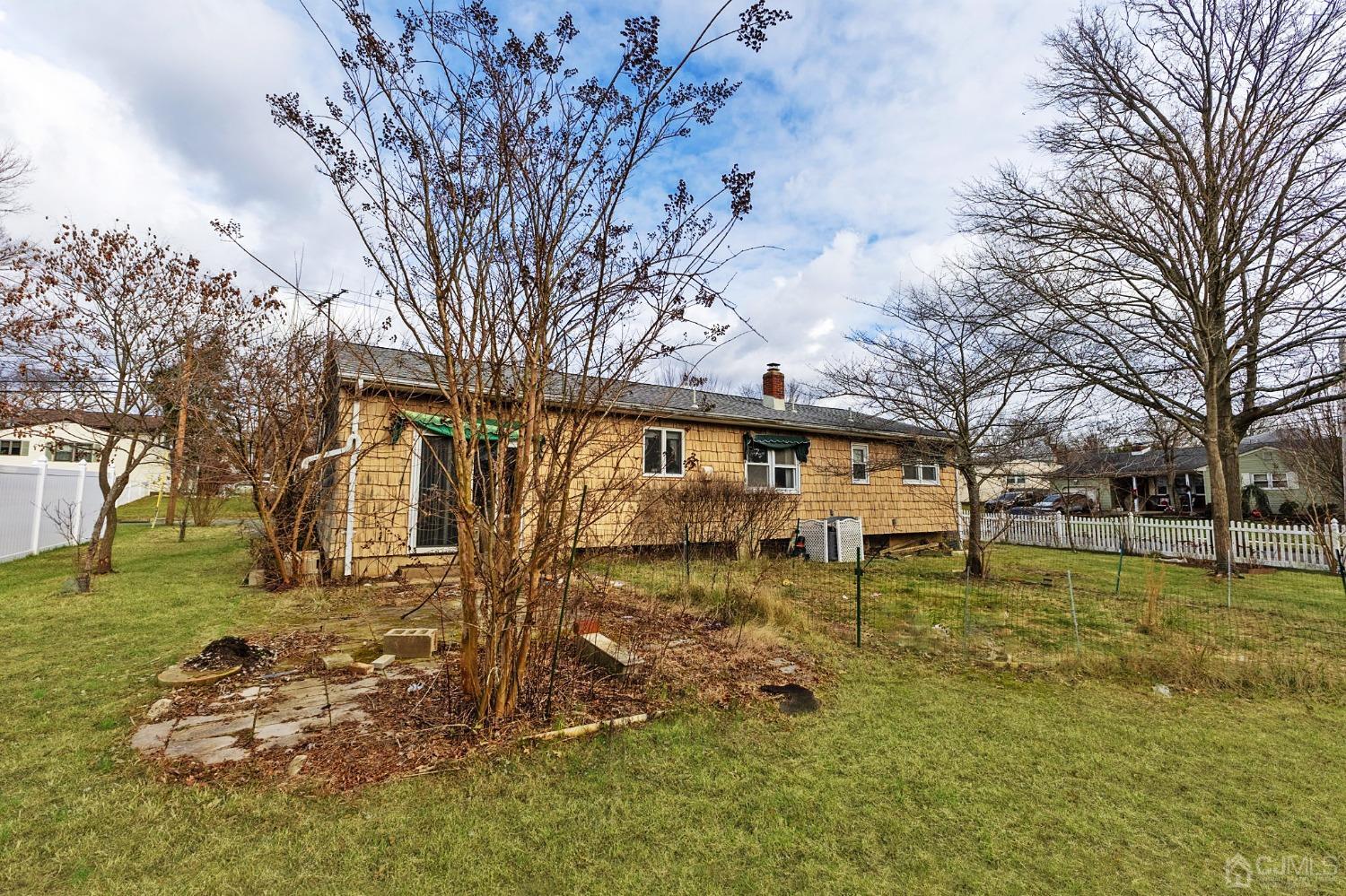 8 Mathison Place Milltown, NJ 08850 - Photo 2 of 17 a backyard of a house with large trees and outdoor seating