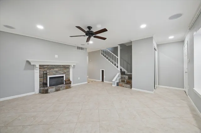 a view of an empty room with a fireplace and a window