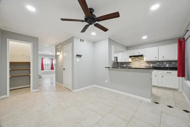 a kitchen with a refrigerator and white cabinets