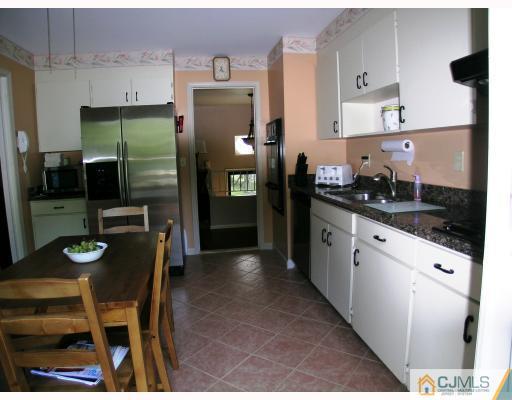 2 Lynnwood Road Edison, NJ 08820 - Photo 4 of 8 a kitchen with a sink a refrigerator and chairs