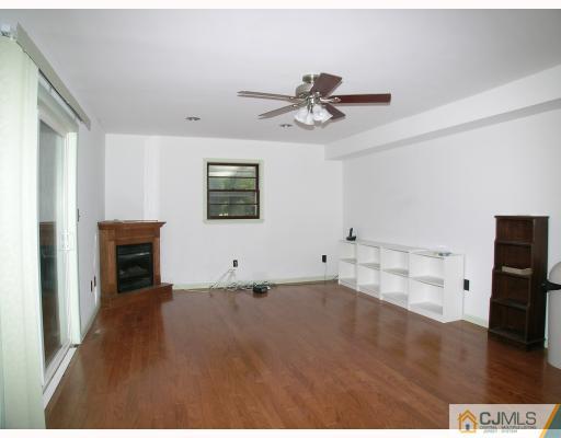 2 Lynnwood Road Edison, NJ 08820 - Photo 6 of 8 a view of empty room with wooden floor and fireplace