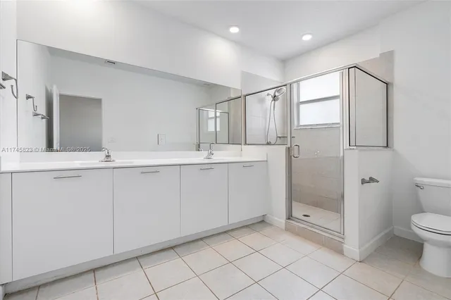 a bathroom with a granite countertop sink mirror and toilet