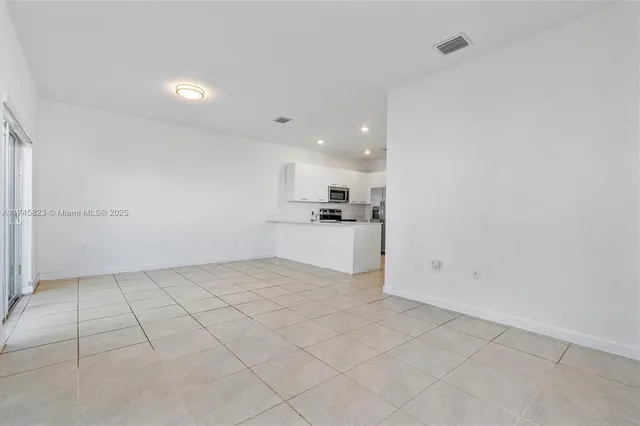 a view of a kitchen with a sink and an empty room