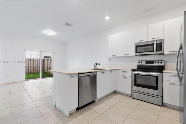 a kitchen with stainless steel appliances a stove microwave and sink