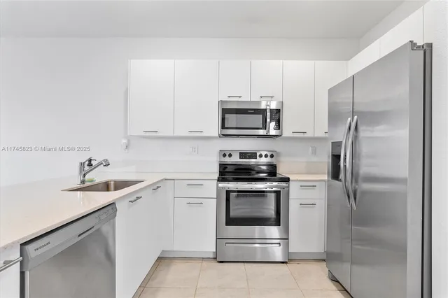 a kitchen with a sink appliances and cabinets