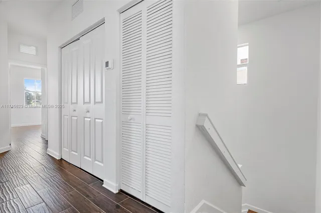 a view of a hallway with wooden floor and staircase