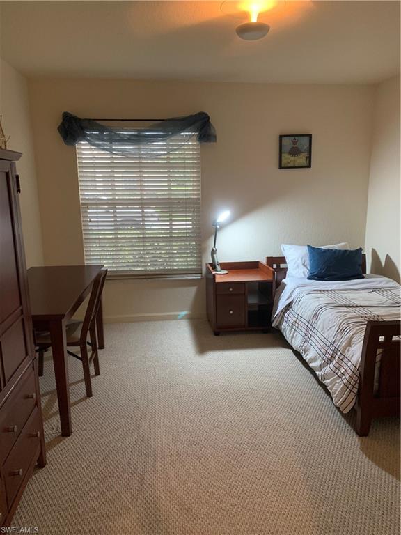 7057 Timberland Circle Naples, FL 34109 - Photo 11 of 22 a bedroom with a bed and a table