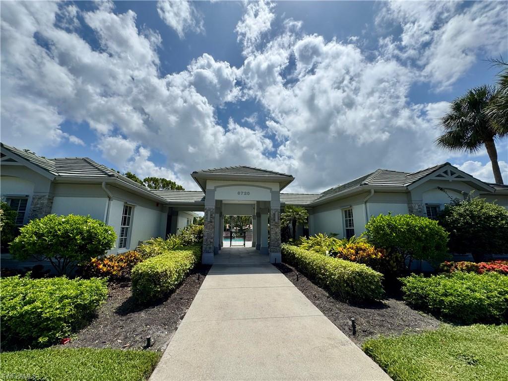 7057 Timberland Circle Naples, FL 34109 - Photo 14 of 22 a front view of a house with a garden