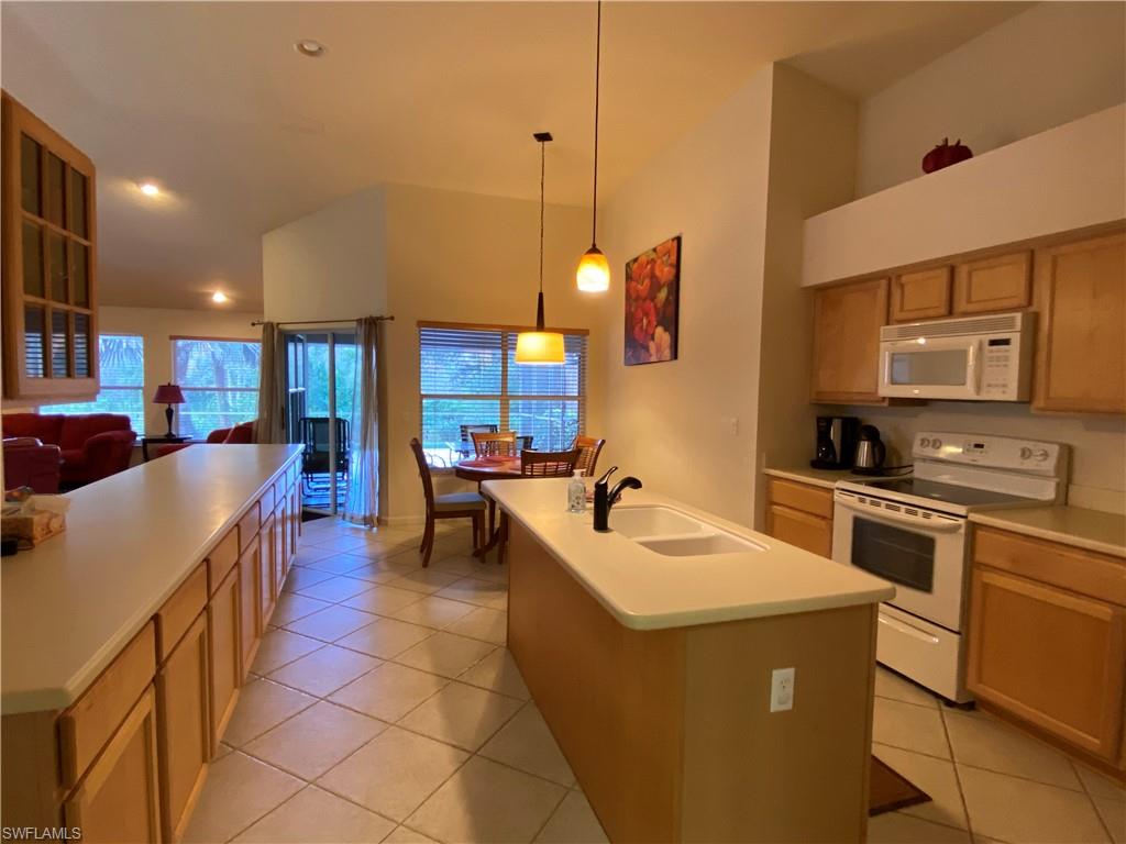 7057 Timberland Circle Naples, FL 34109 - Photo 3 of 22 a kitchen with stainless steel appliances granite countertop a sink a stove and a refrigerator